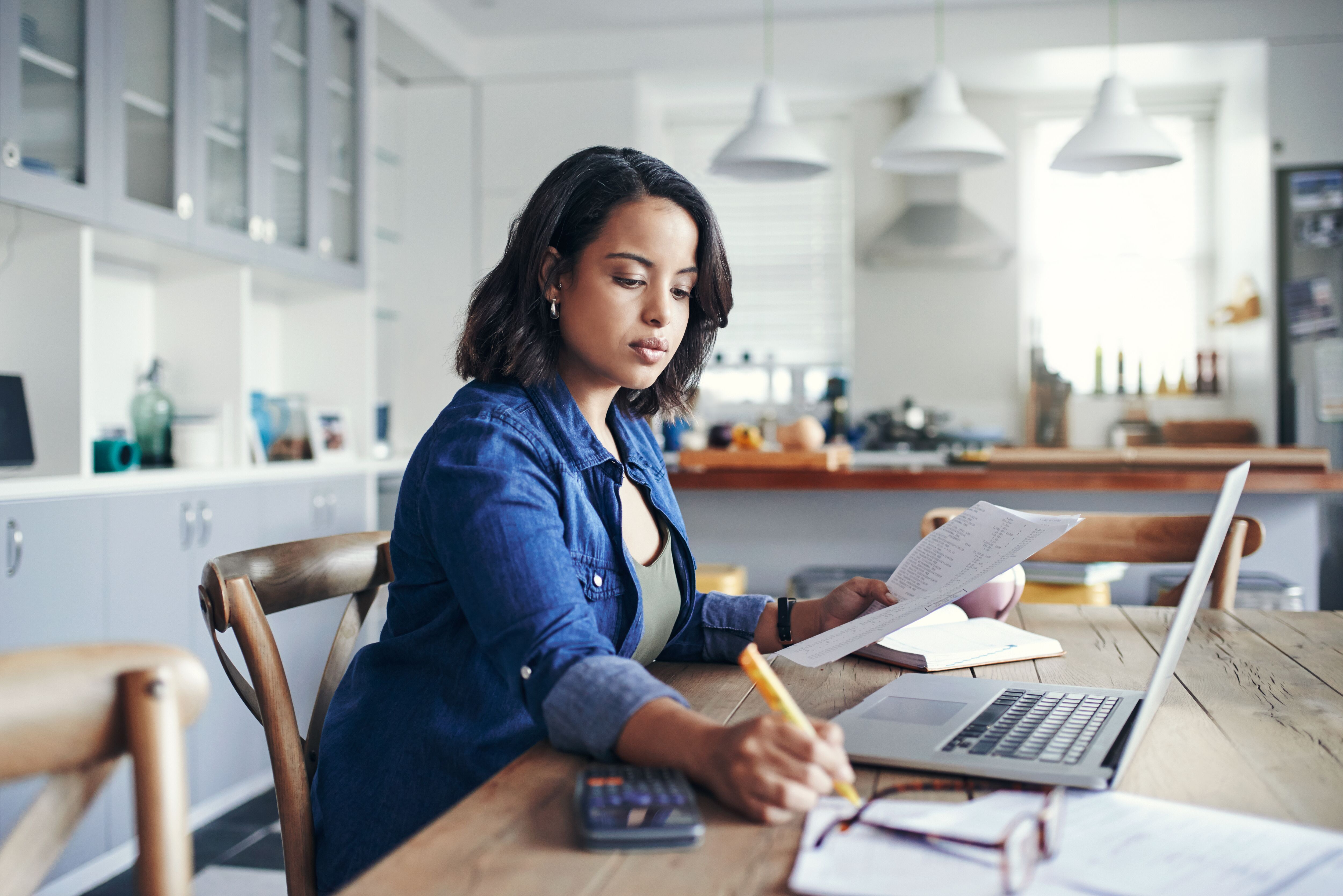 Woman working on her finances at the kitchen table