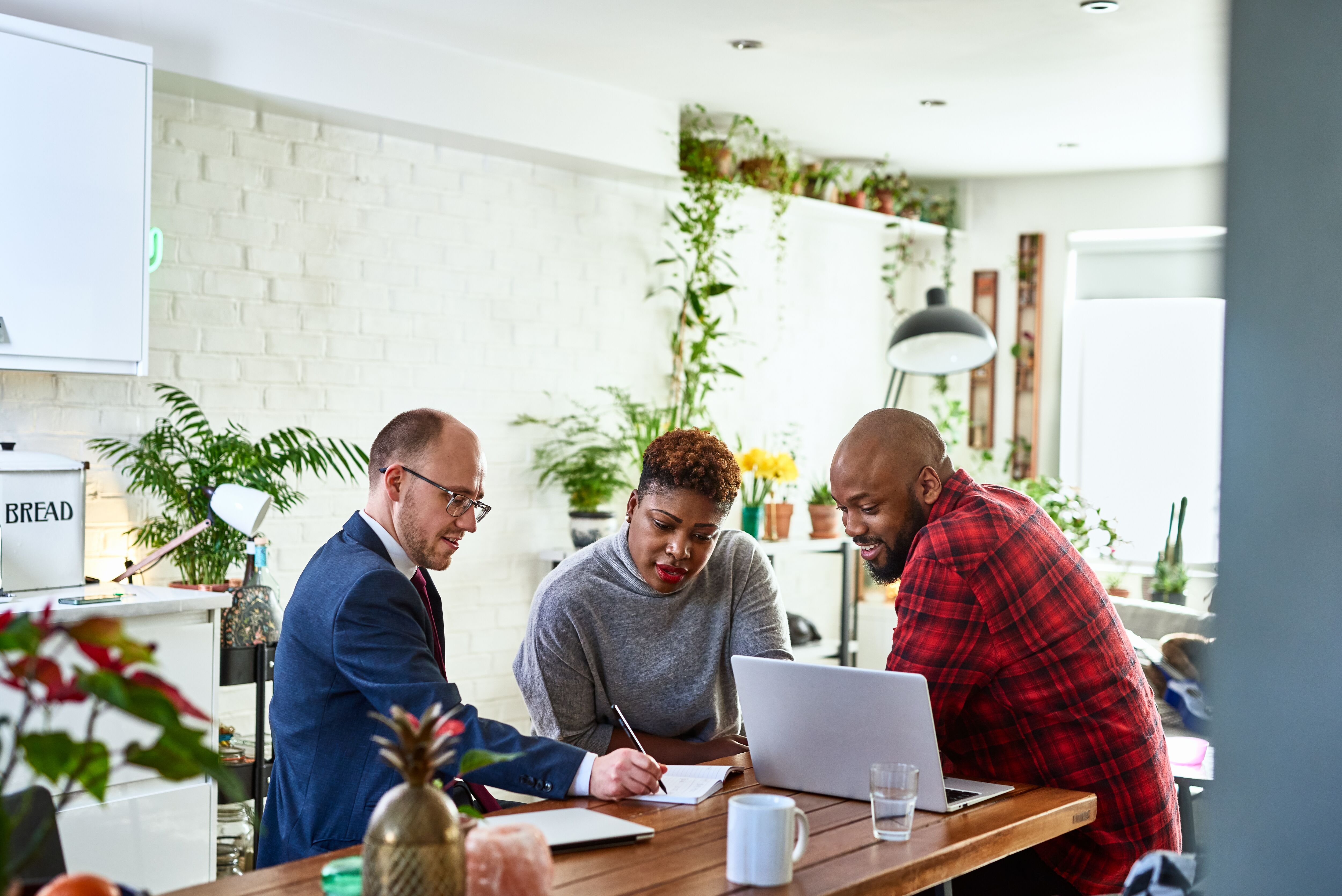 Couple listening to financial advisor at home with laptop.
