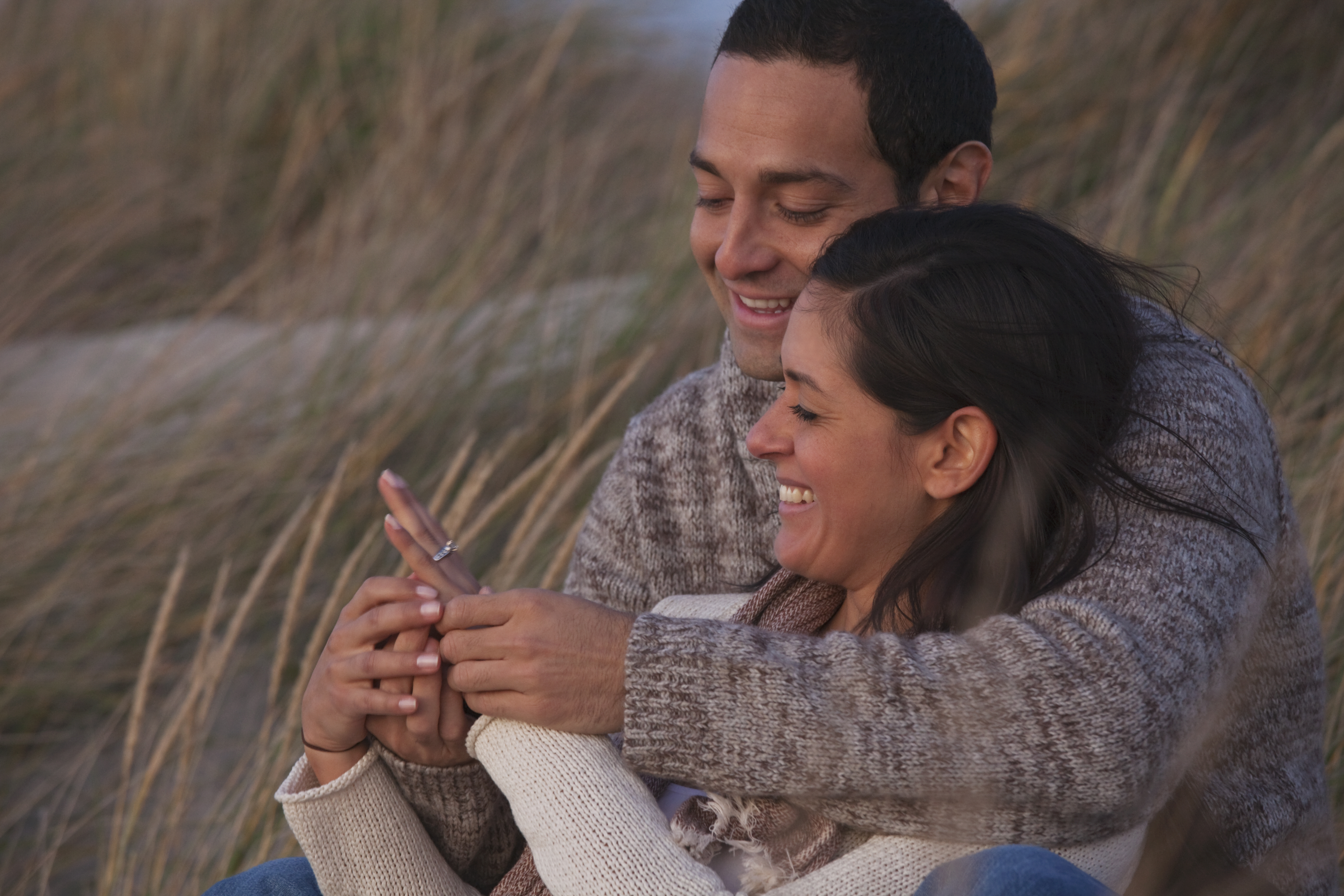 Hispanic couple looking at engagement ring