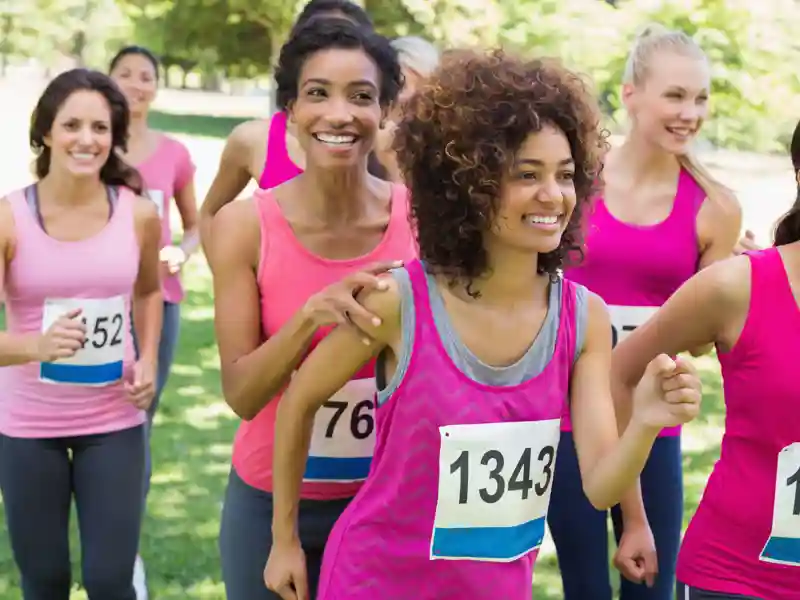 Smiling female participants of marathon running in park.