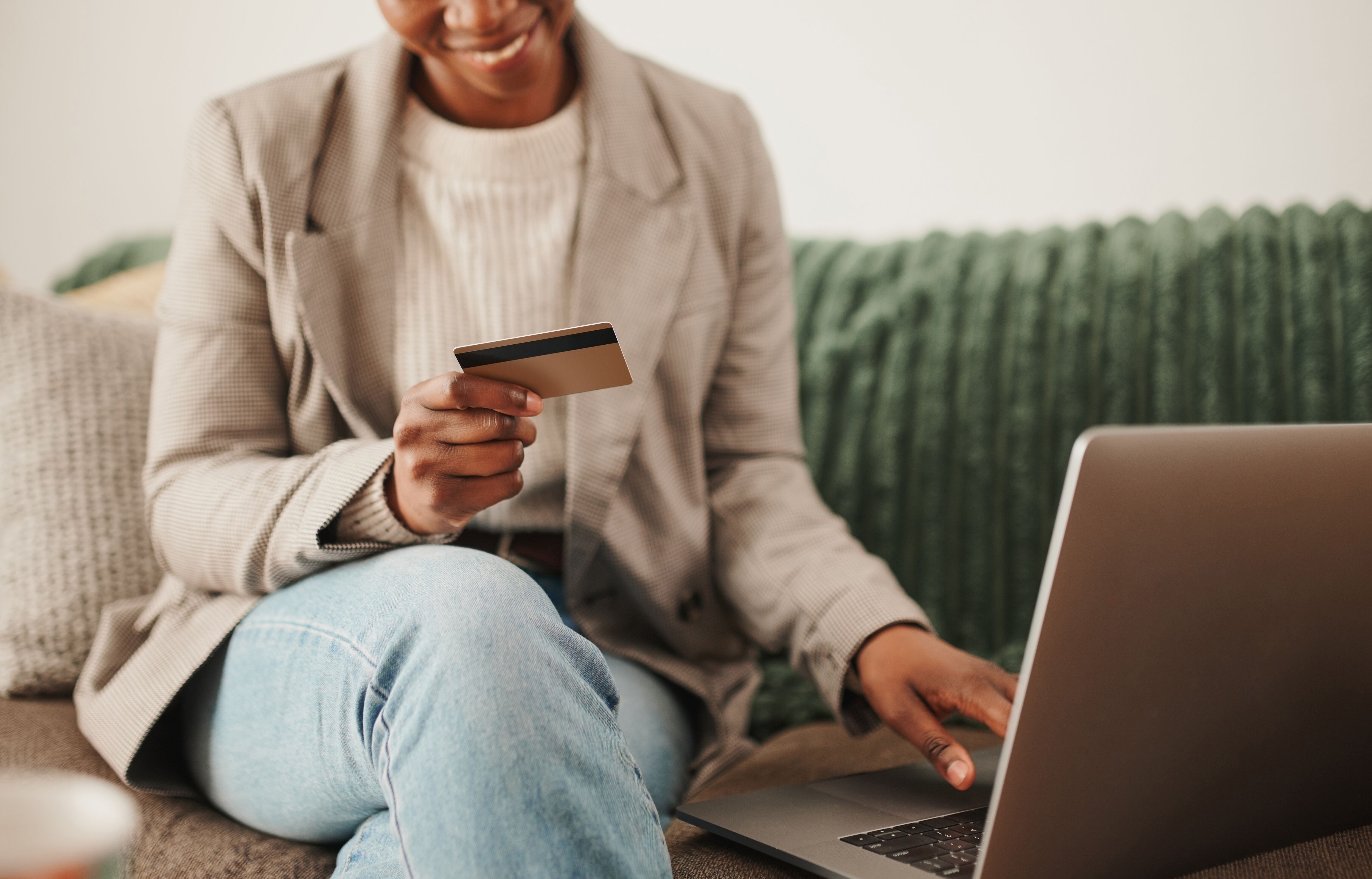 Person using a credit card and laptop at home