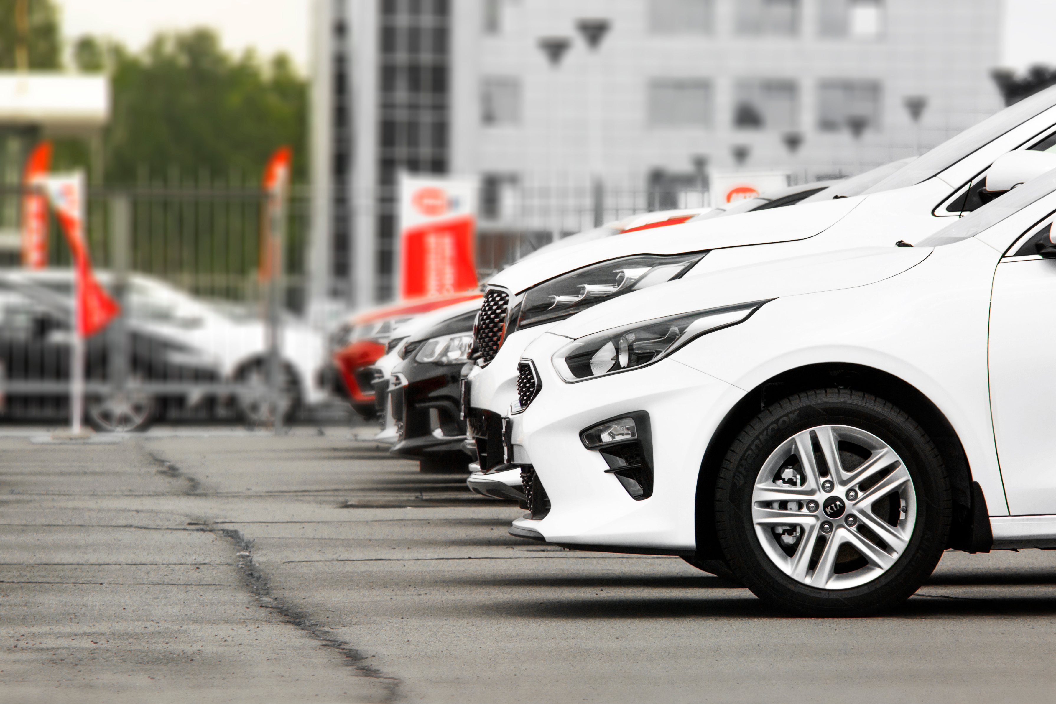 Row of cars for sale at an auto dealership.
